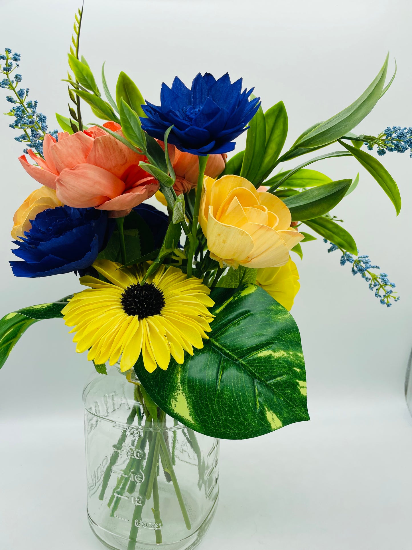 Multi color arrangement on glass jar vase